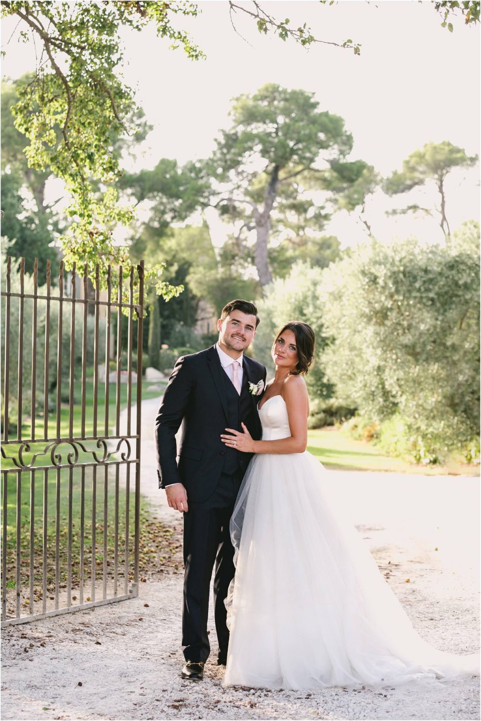 Newly married couple by gates at Mas de las Rose