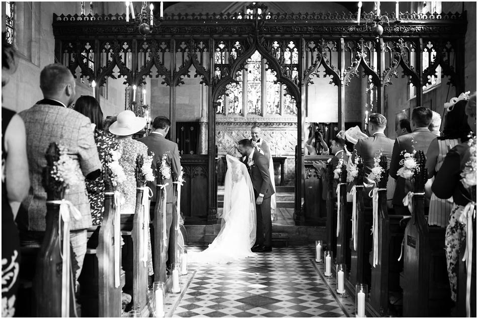 Couple kiss at the altar on their Sudeley Castle Wedding day