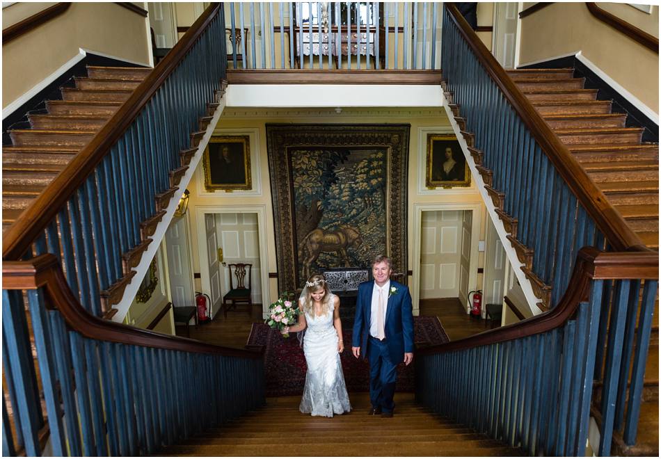 Bride walking up the grand staircase at Doddington Hall