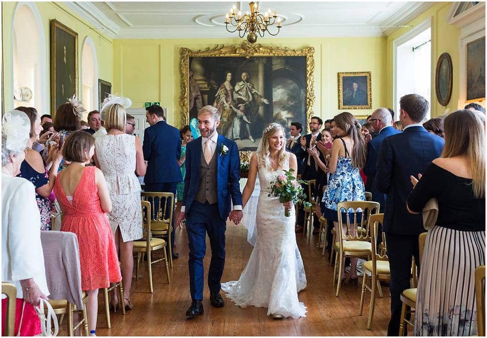 newly weds walk down the aisle at their Doddington Hall wedding