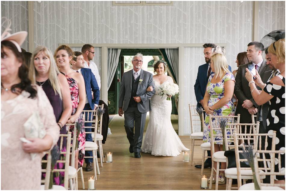 Bride and her Dad walking down the aisle on her wedding day at Hampton Manor