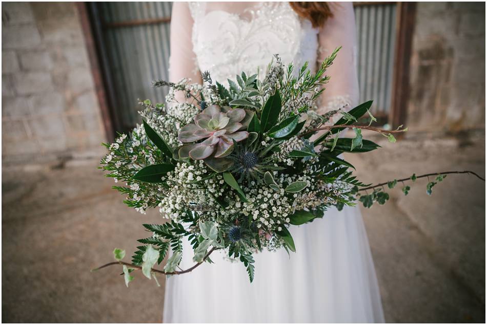 Bride holding a bouquet of succulents and foliage on her wedding day