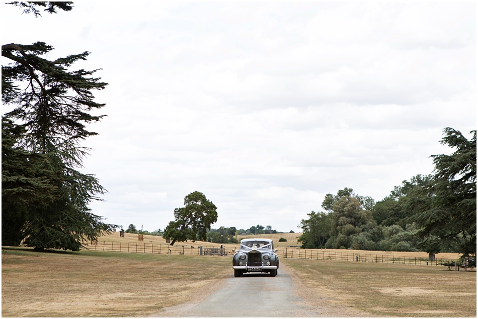Bride arriving down the the driveway of Compton verney