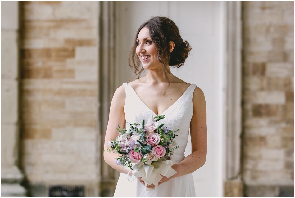 Compton Verney wedding photography; portrait of Bride holding bouquet of pink roses, with relaxed hair up hairstyle