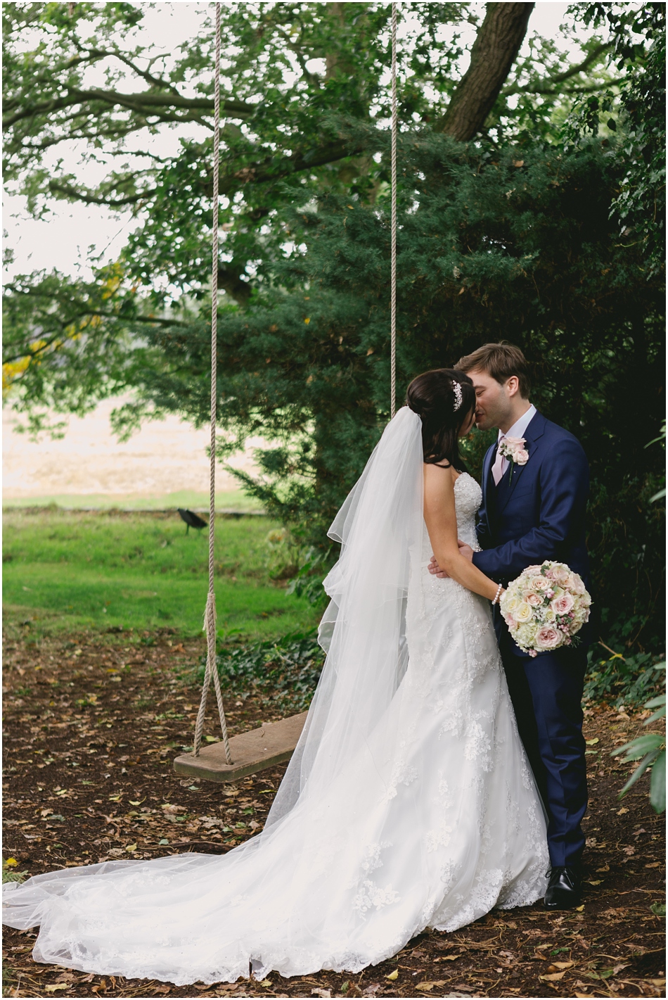 Romantic Iscoyd Park wedding; portrait of Bride and Groom kissing by the swing on their wedding day