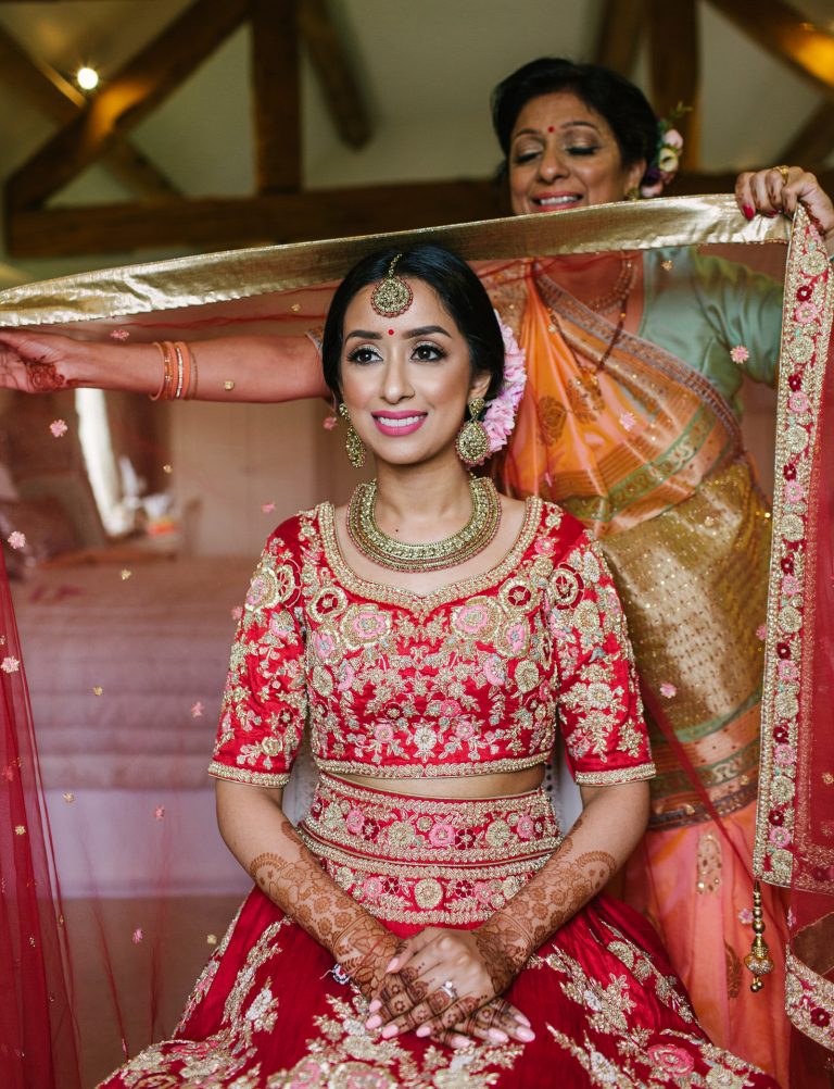 Indian Bride wearing traditional red outfit, getting ready in the Bridal Suite at Alrewas Hayes