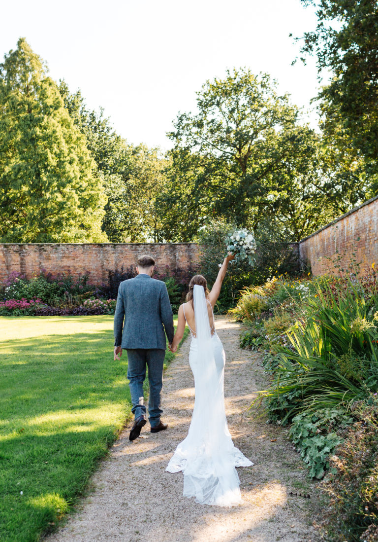 Thorpe Garden photography; Bride and Groom walking in the walled garden