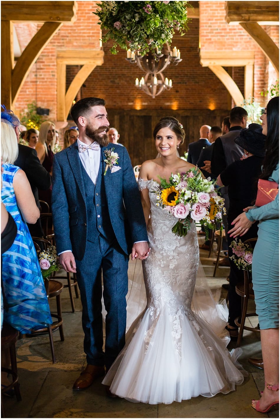 Shustoke Barn wedding photography; Couple walking down the aisle on their wedding day