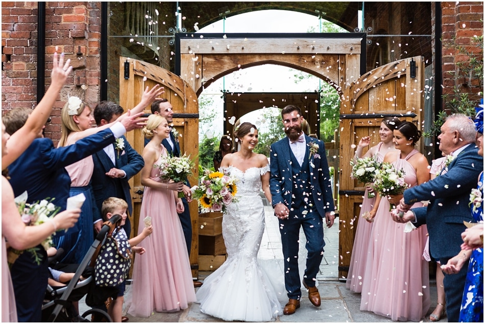 Couple walking out to confetti at Shustoke Barn Wedding