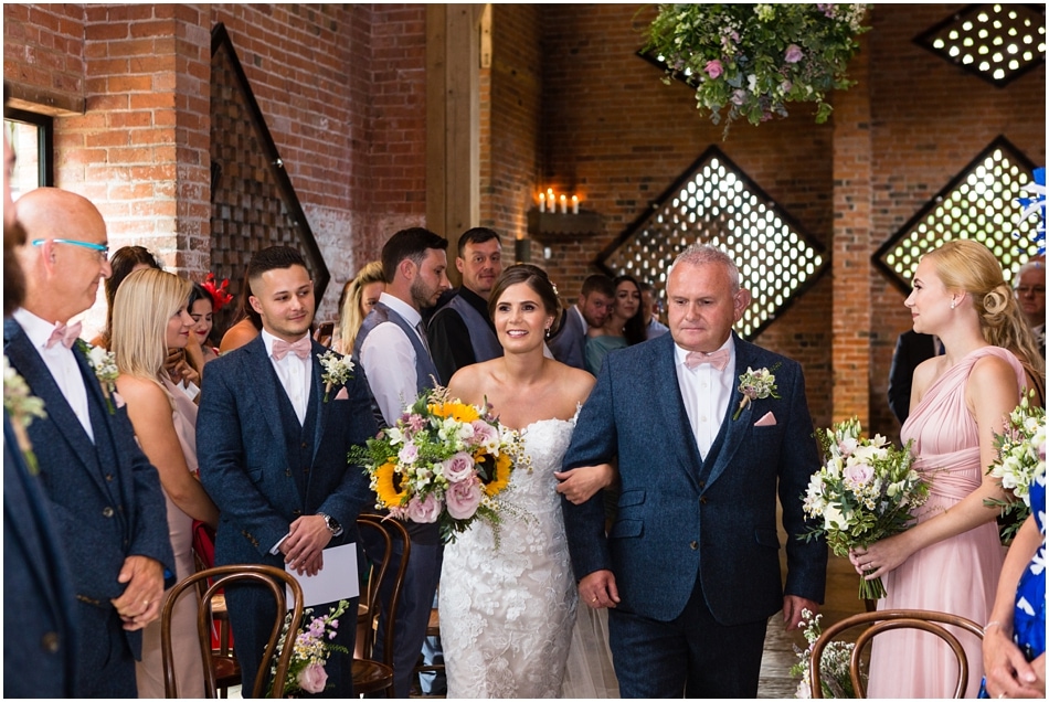 Bride walking down the aisle with her Father at her Shustoke Barn wedding