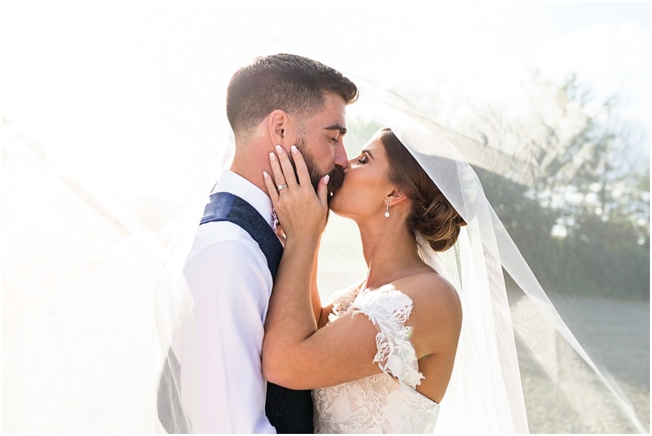 Shustoke Barn wedding photography; Bride and Groom kissing under veil