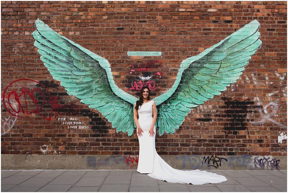 SIren Liverpool wedding photography; Bride with angel wings graffiti