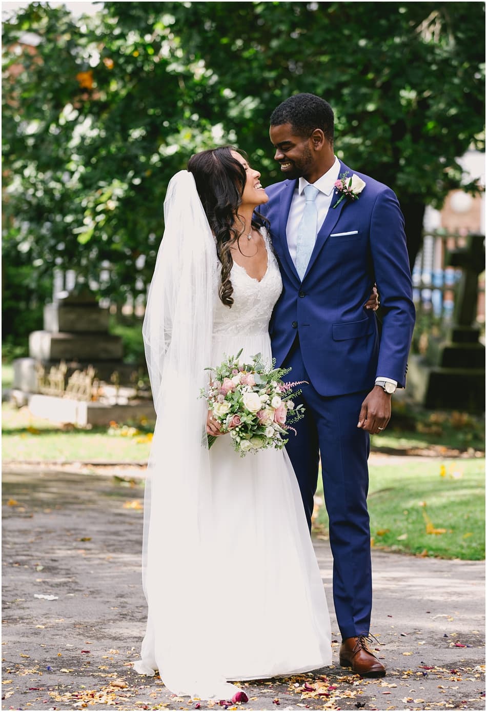 Couple stand outside St Mary's Church, Sheldon on their wedding day