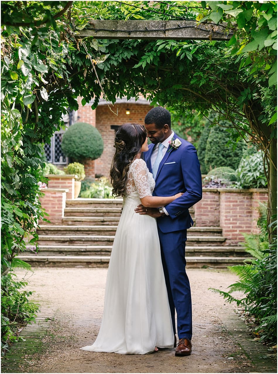 Gorcott Hall wedding photography; couple stand under a leafy archway