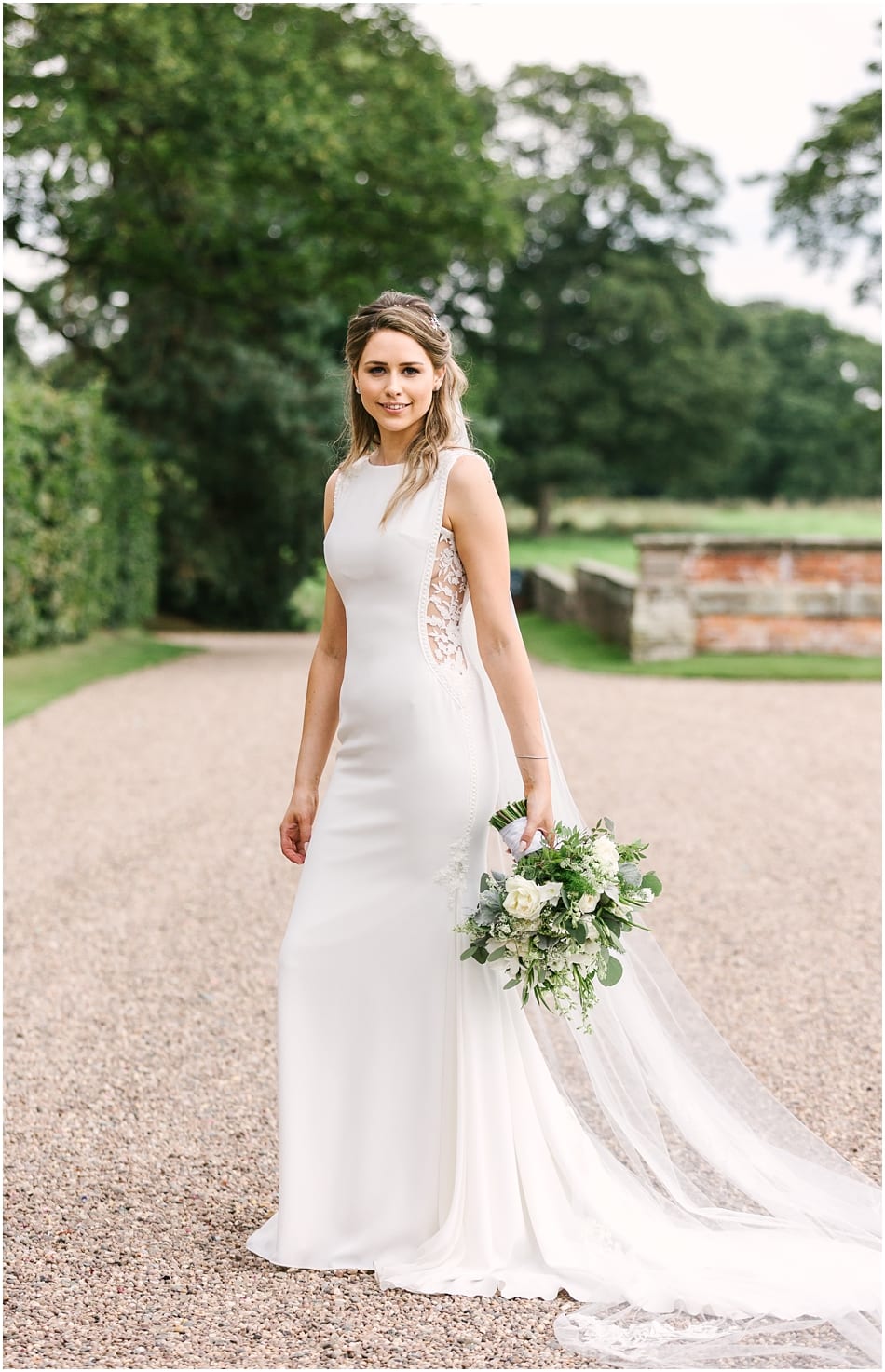 Bride wearing Pronovias fitted dress with lace side panel at her Iscoyd Park wedding