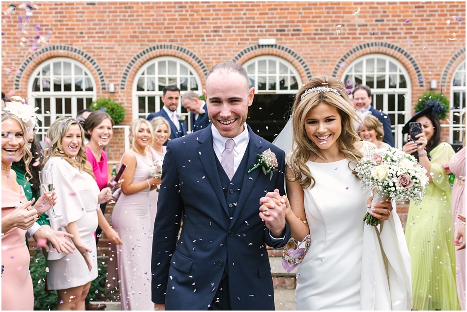 Alrewas Hayes wedding photography; couple walking through confetti