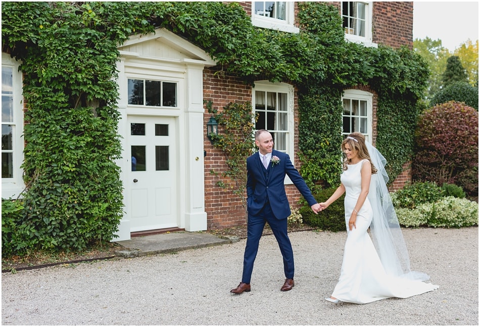 Documentary style wedding portrait of Bride and Groom walking at their country house wedding