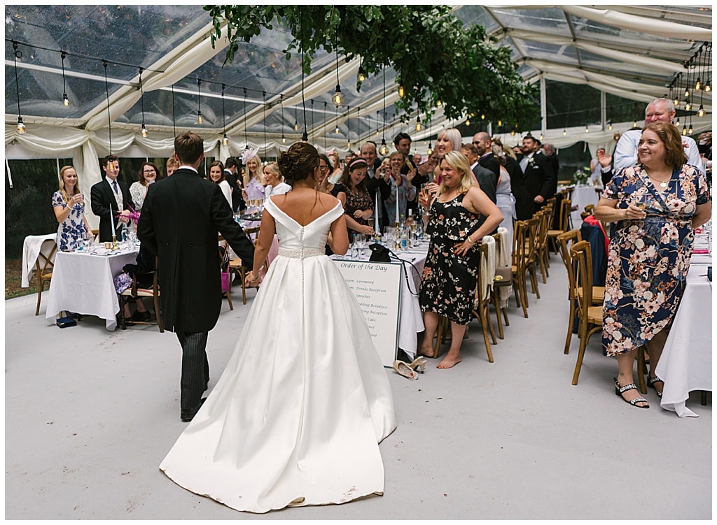 Newlyweds enter thier Woodland Marquee Reception with Eddison light bulbs