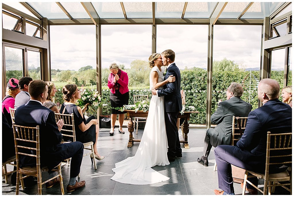 Newly married couple kiss in their small wedding ceremony at Eckington Manor