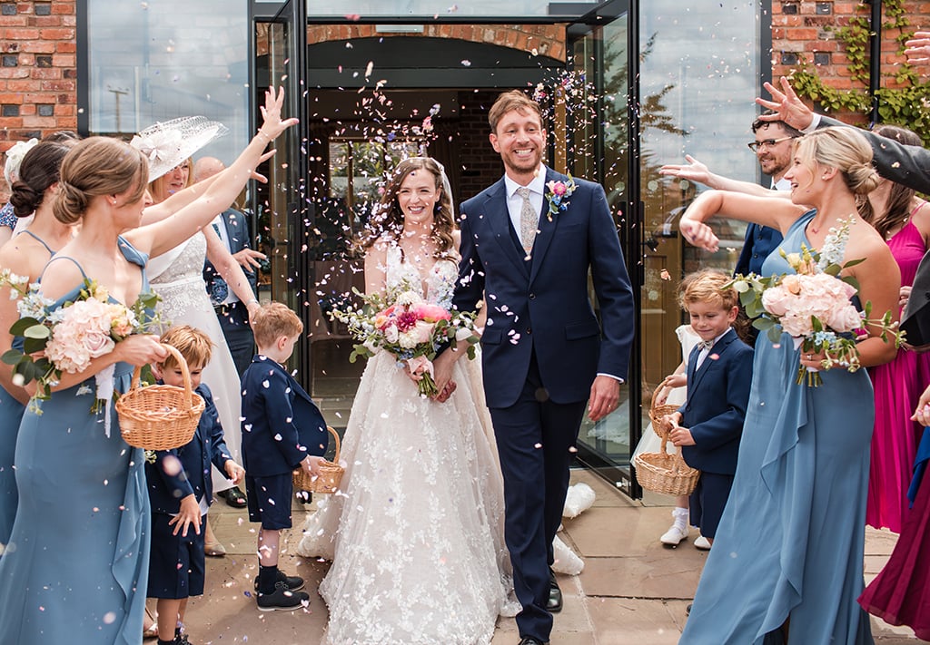Bride and Groom walk out to confetti at Curradine Barns