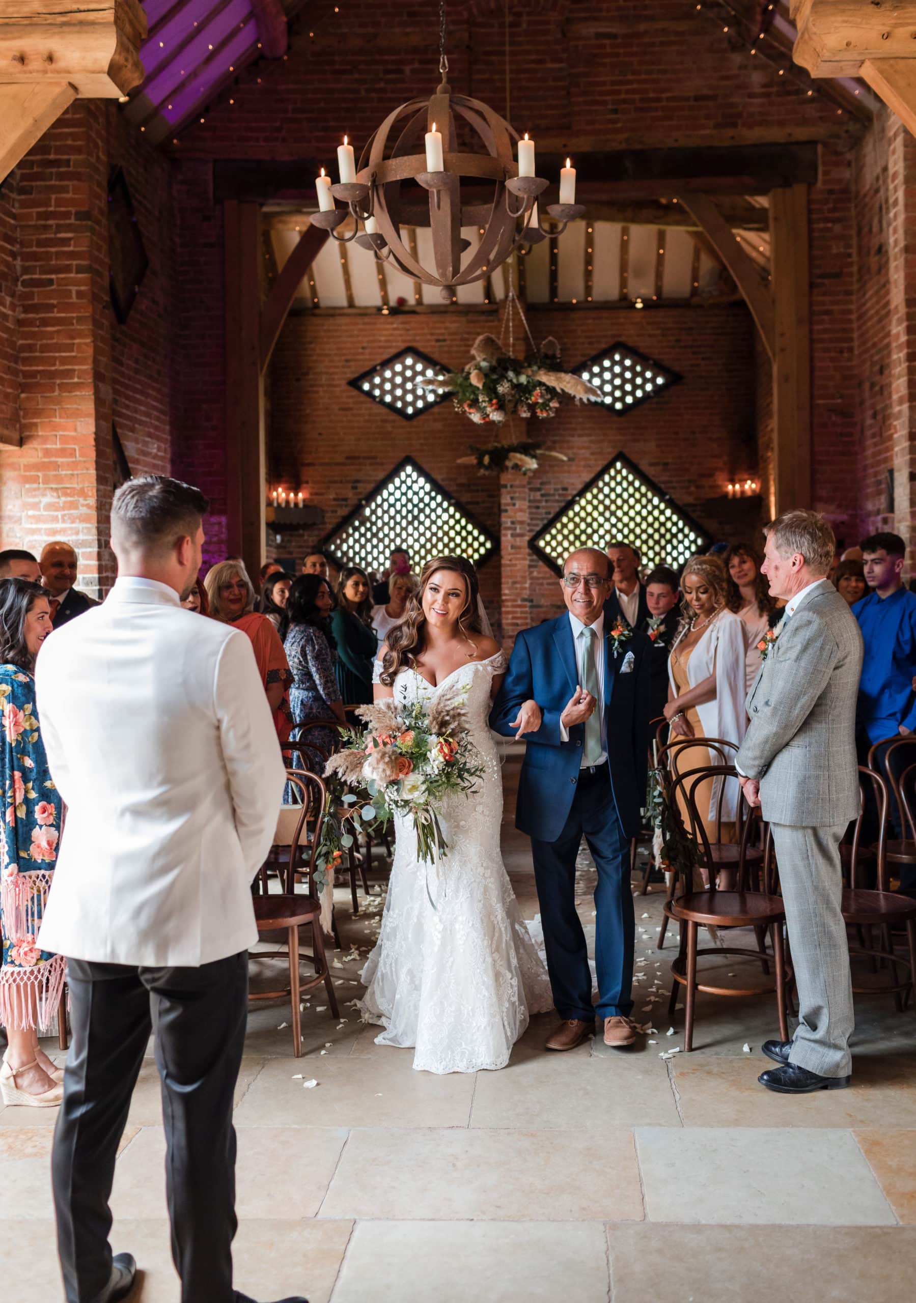 Bride walks down the aisle of Shustoke Barn with her Dad to her waiting Groom