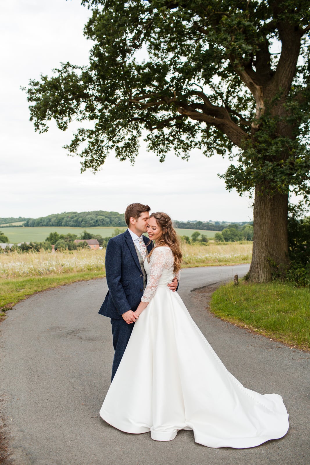 Bridge and Groom share a kiss with a view of Swallows Nest Barn