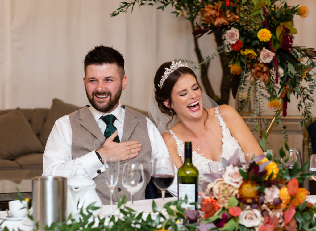 Bride and Groom laughing during speeches at their Alrewas Hayes wedding