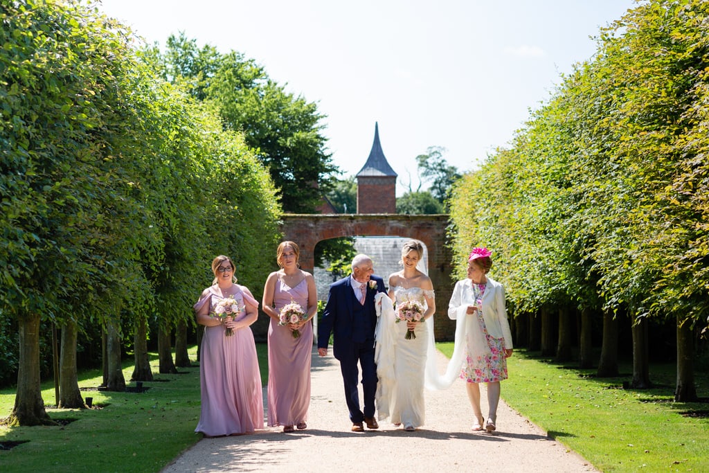 Bride walking with Bridesmaids at Combermere Abbey