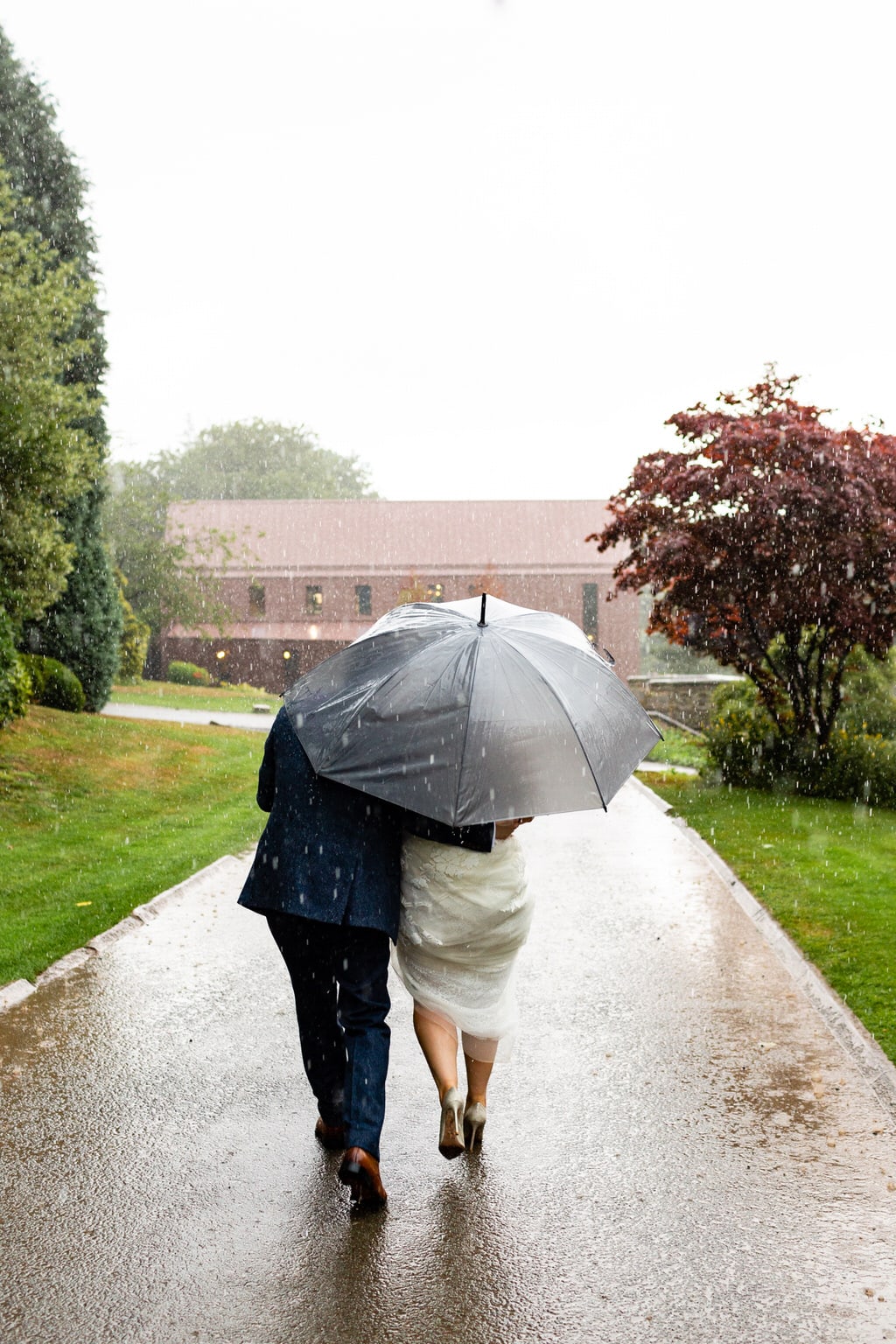 Foxtail Barns wedding photography; Bride and Groom walking in the rain with umbrella