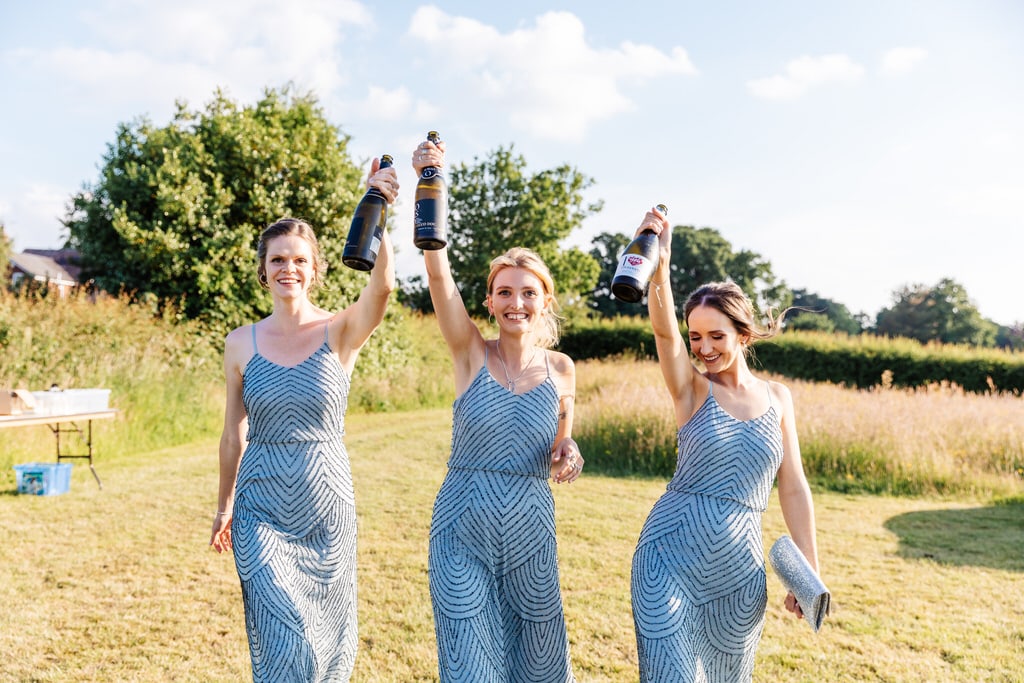Bridesmaids walking with bottles of bubbly