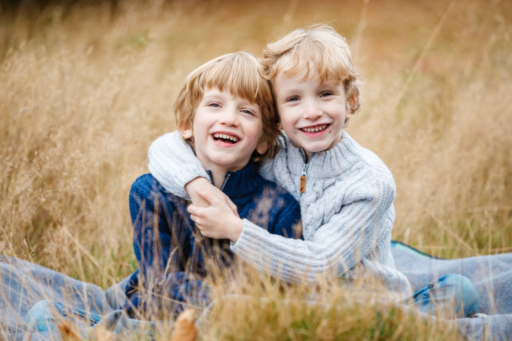 family photoshoot in Birmingham; two brothers laughing with arms round each other