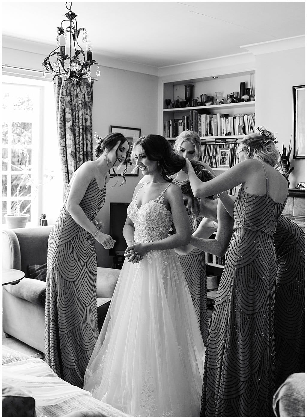 Bride being helped into her wedding dress by bridesmaids