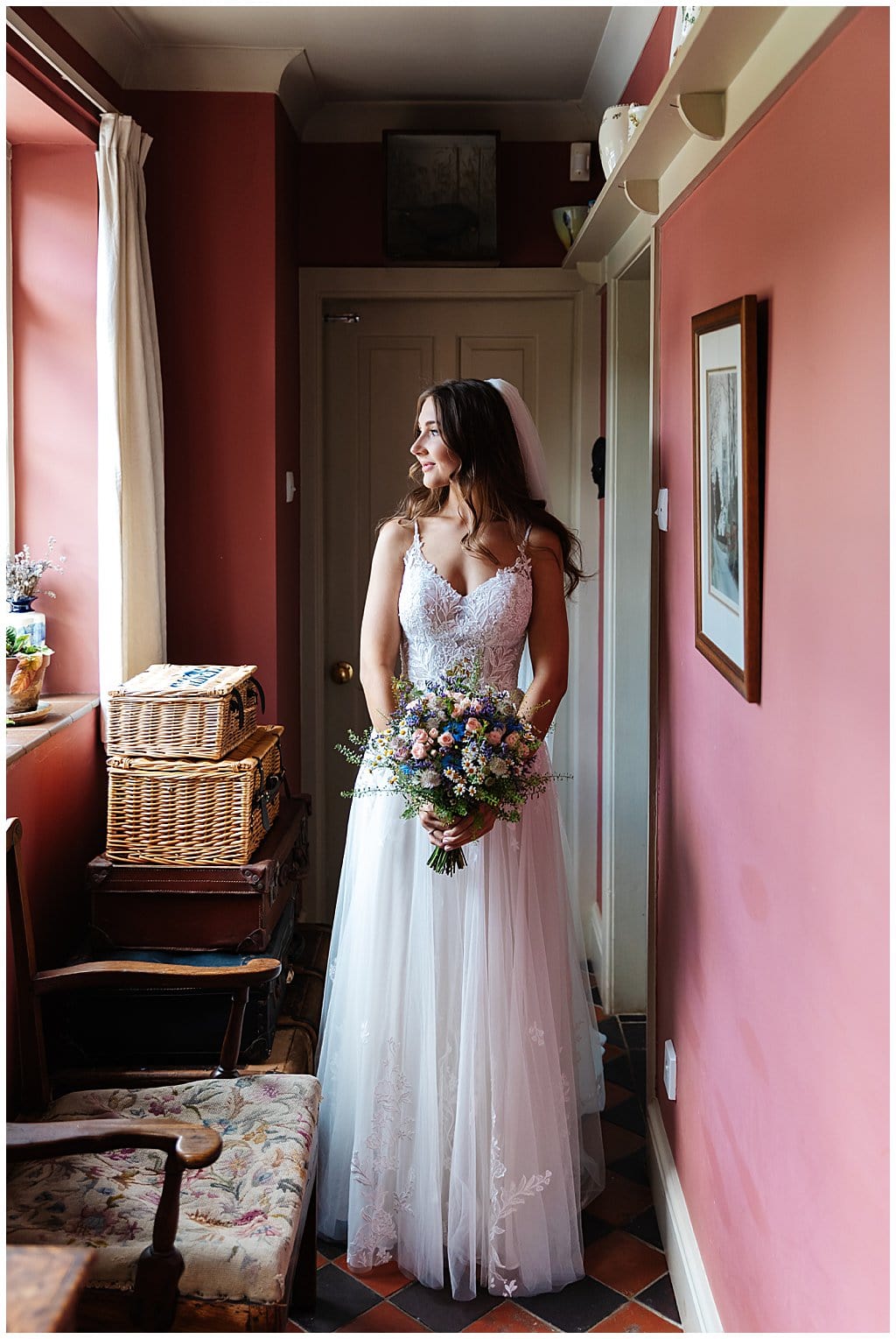Bride wearing fitted lace bodice with chiffon skirts Pronovias wedding dress, holds country flower bouquet