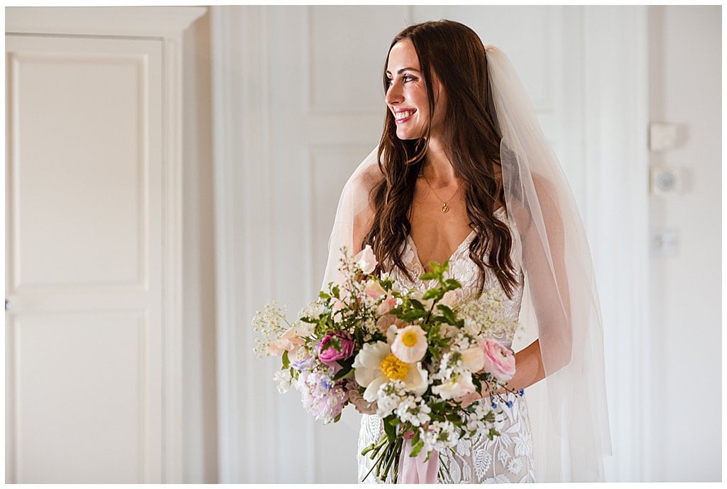 Bride wearing hair down, holding spring bouquet, in Alrewas Hayes bridal suite