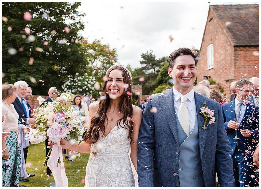 Summer Alrewas Hayes wedding photography of happy newly married couple walk through confetti