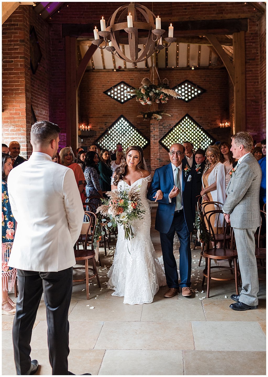 Bride walking down the aisle of Shustoke Barn wedding venue with her Father