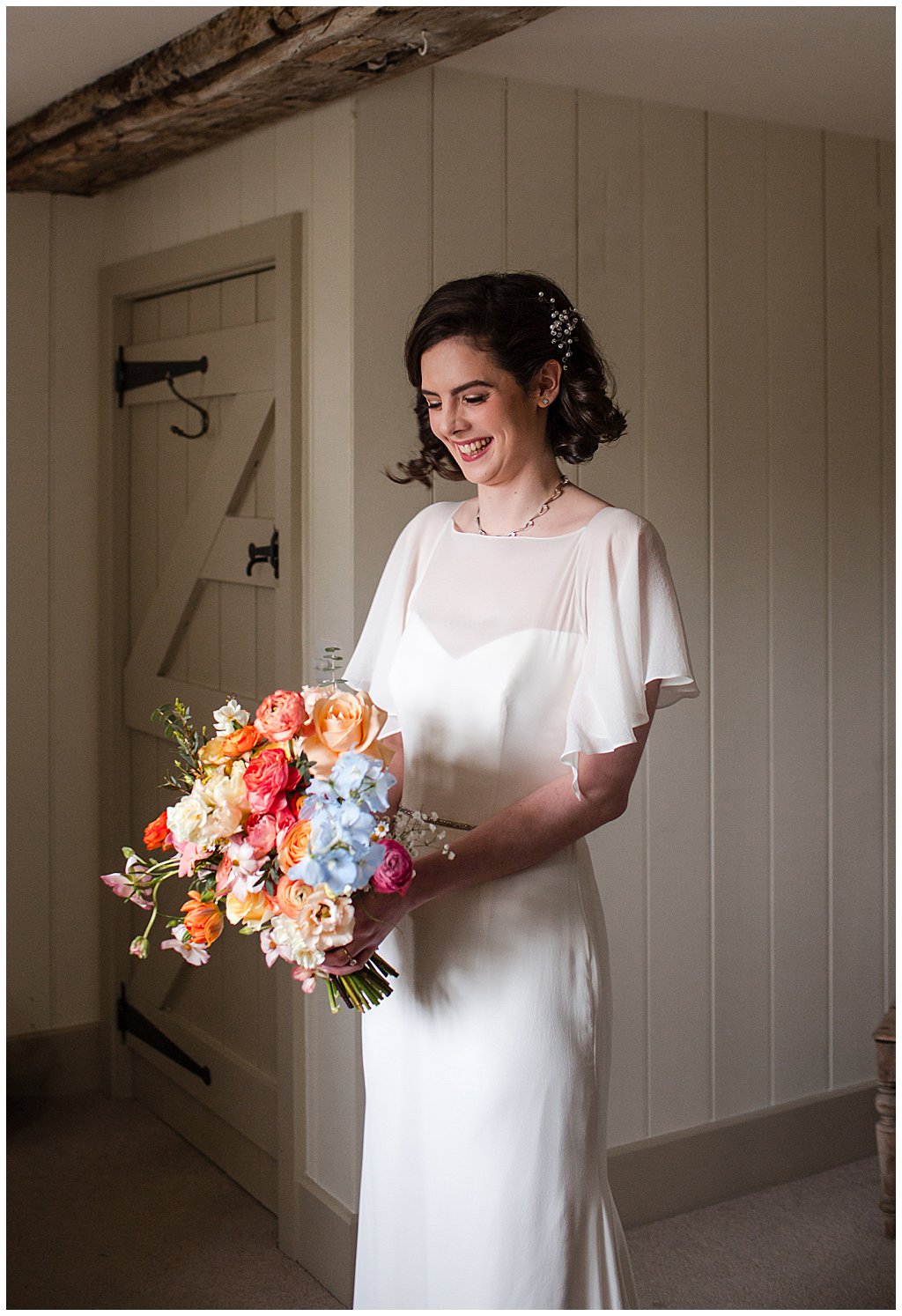 Bride holding a colourful bouquet at a fun Spring wedding at Pimhill Barn