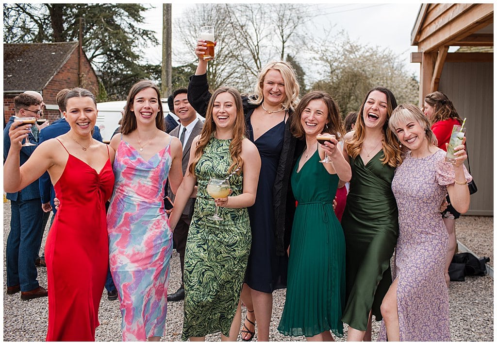 wedding guests enjoying themselves with Cocktails in the courtyard at Pimhill Barn