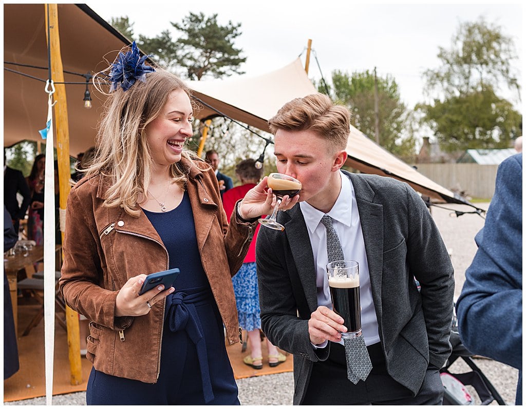 friendly wedding guests drinking cocktails at a Pimhill Barn wedding in the Spring