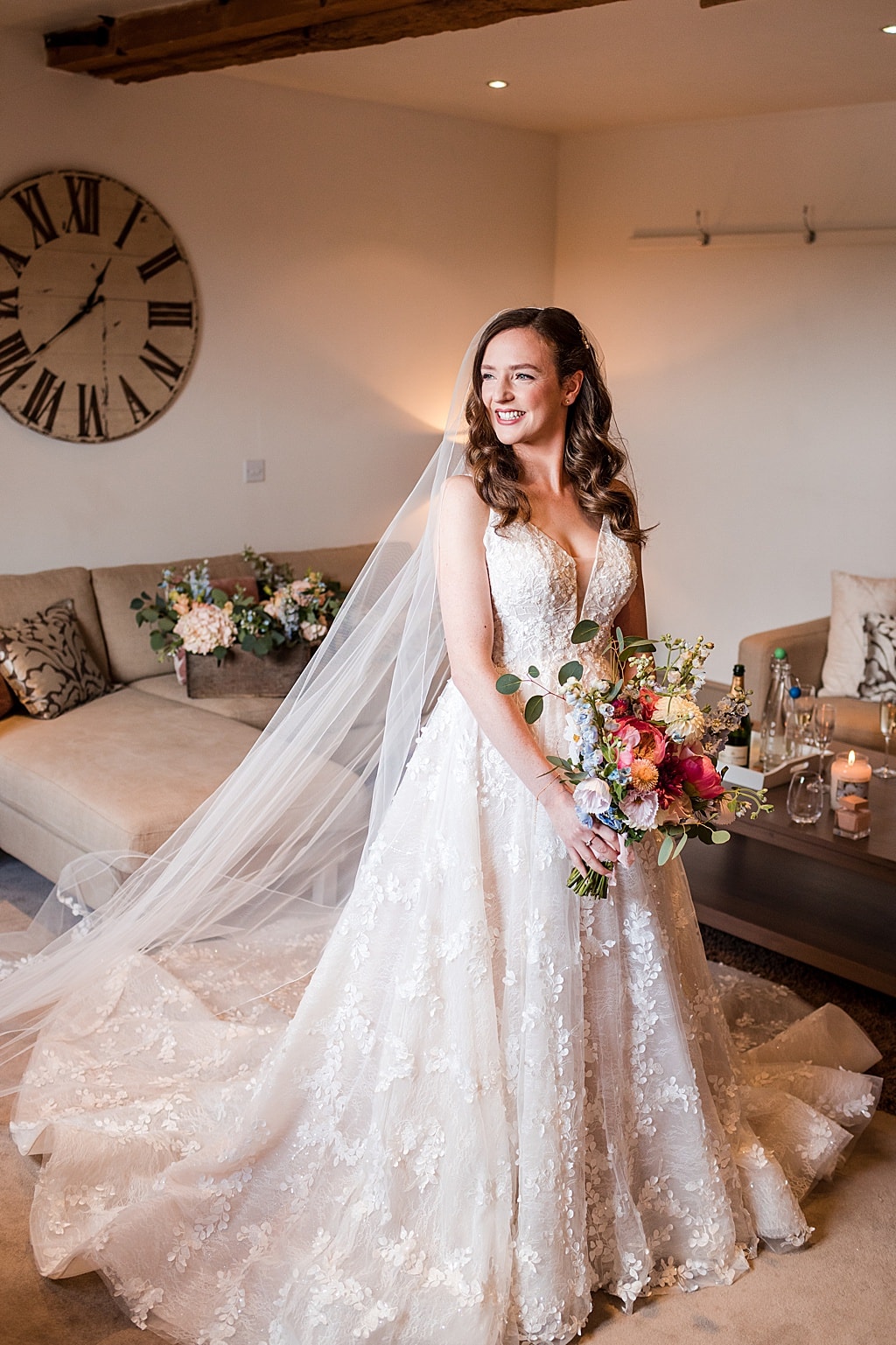 bride wearing A line lace wedding dress stands in the getting ready room at Curradine Barns