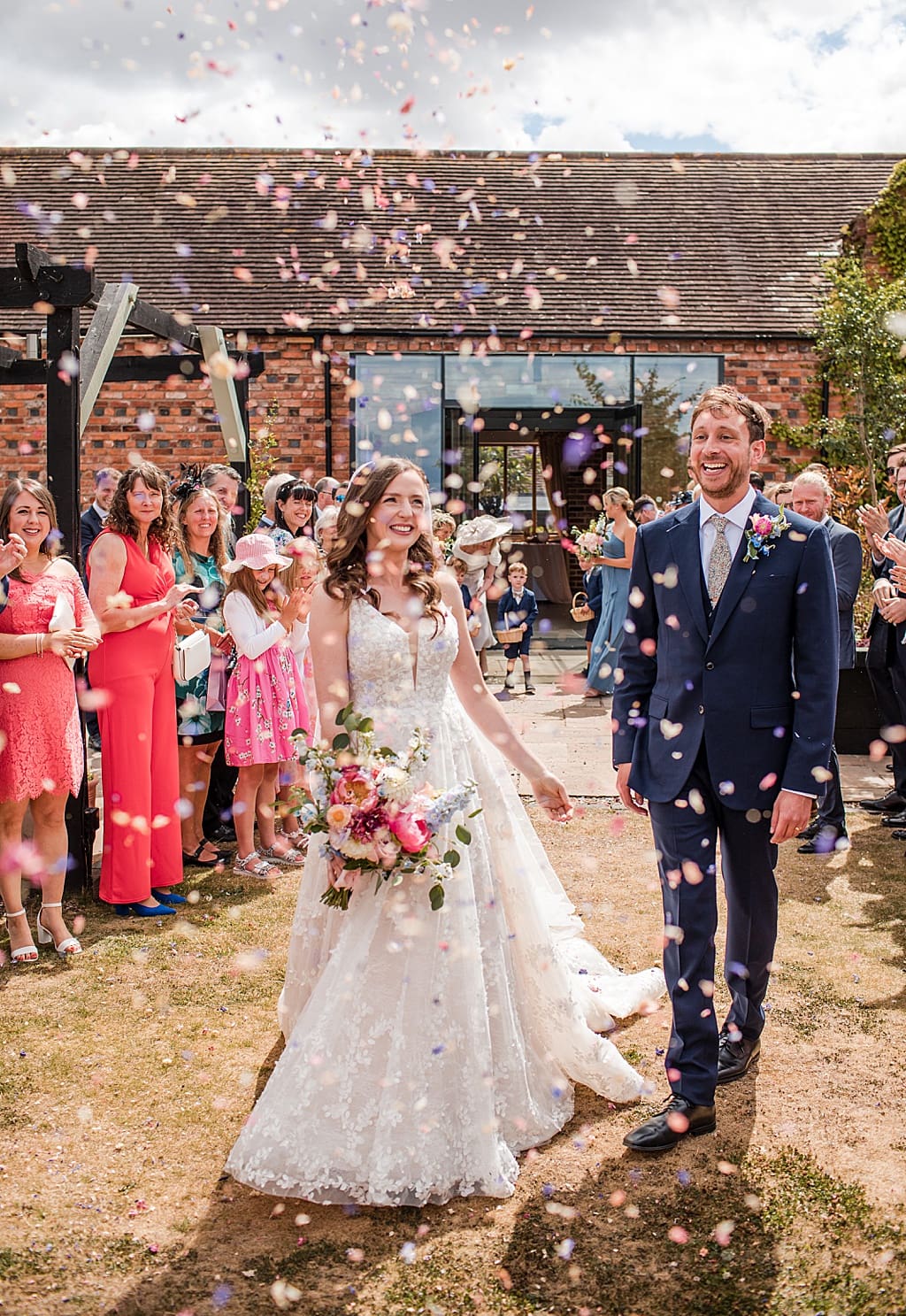 confetti being thrown in the gardens at Curradine Barns