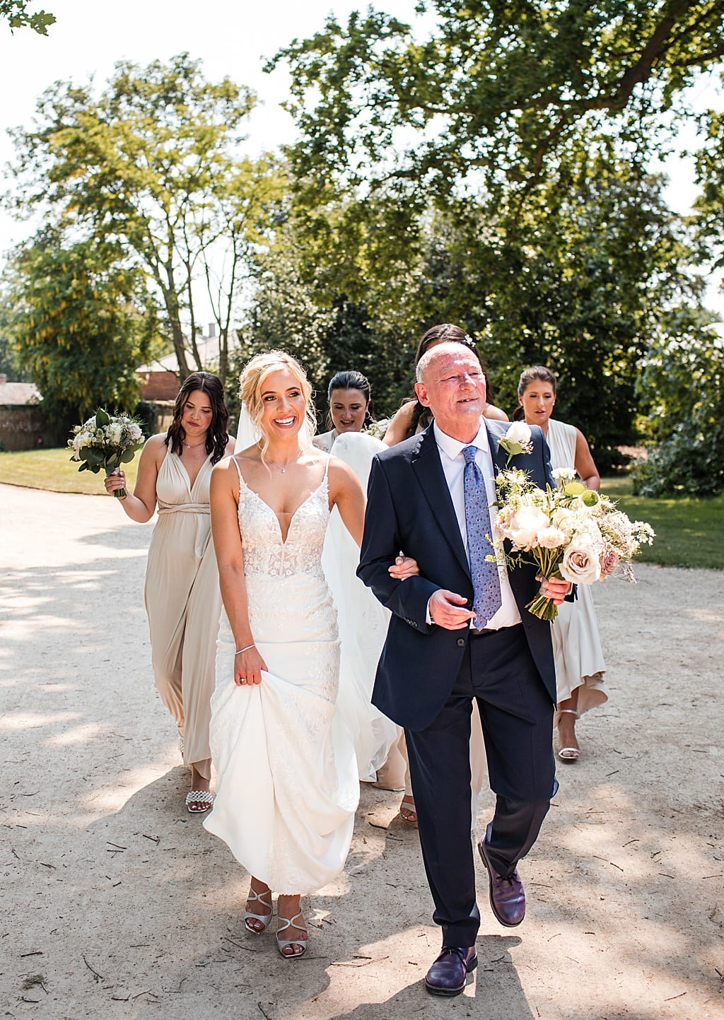 Dad holds bouquet and walks his Daughter to her wedding ceremony at Thorpe Garden