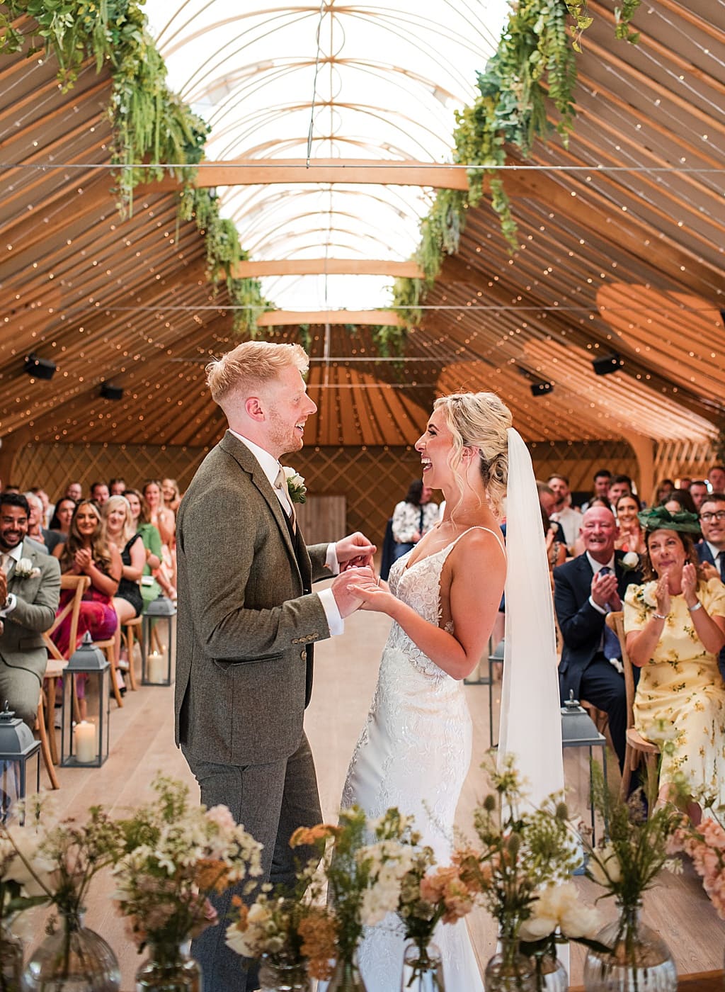 Happy Bride and Groom hold hands during wedding ceremony in a Yurt, during their fun Summer wedding