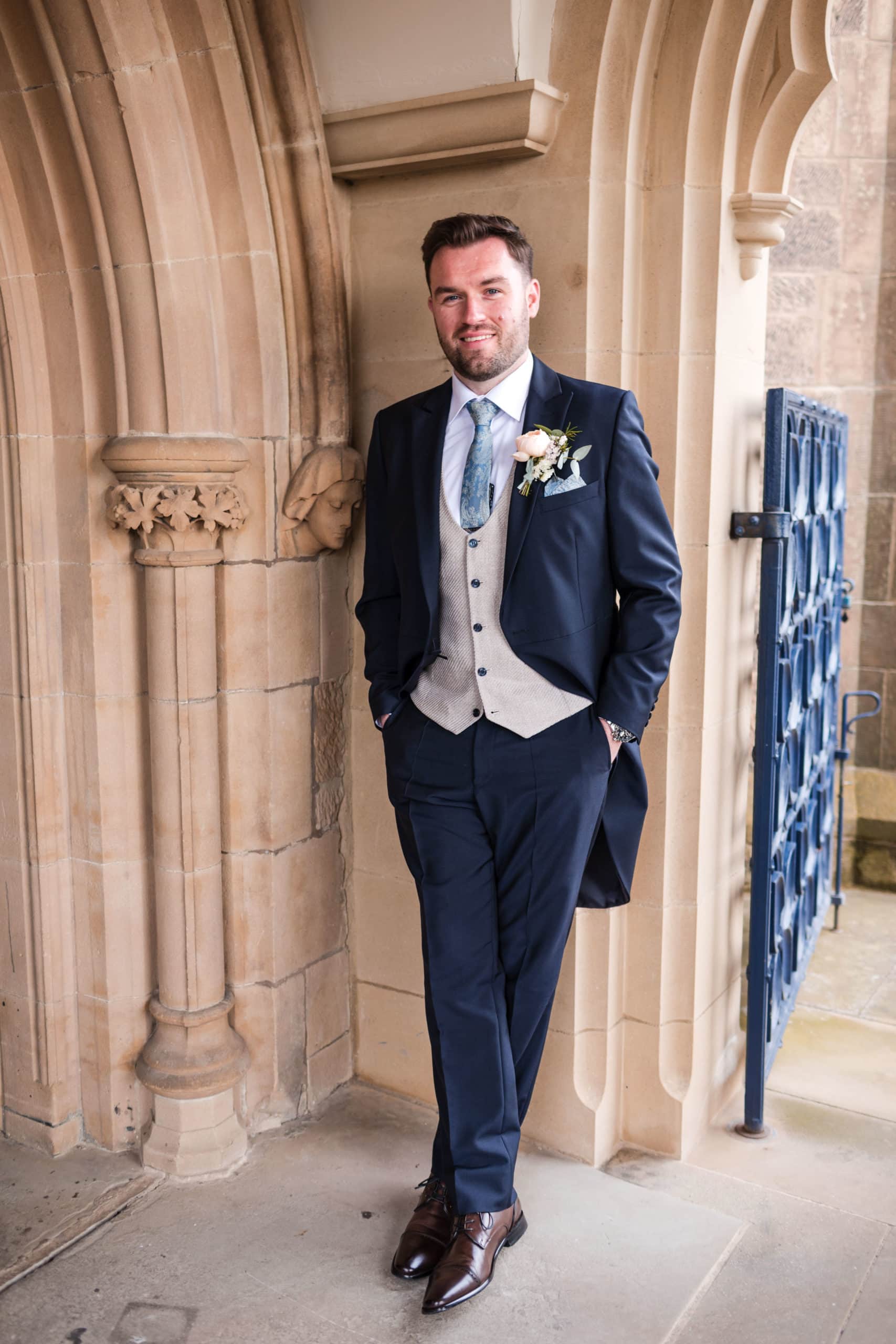 Groom wearing traditional Navy wedding morning suit with pale blue tie at Shrewsbury Cathedral