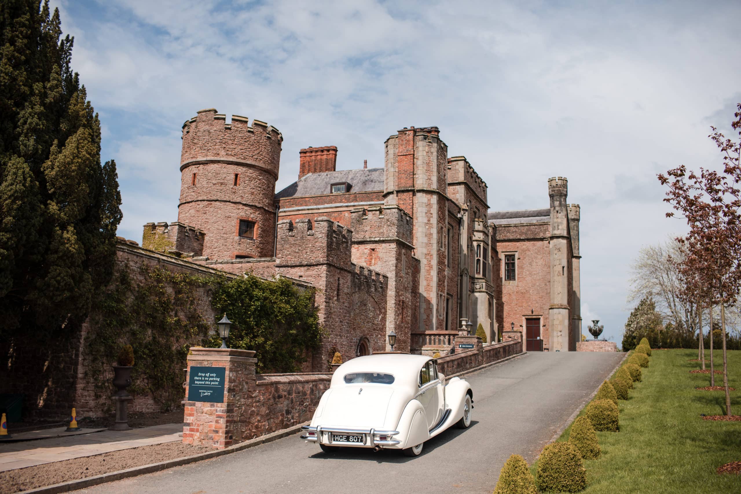 White vintage wedding car arriving at Rowton Castle