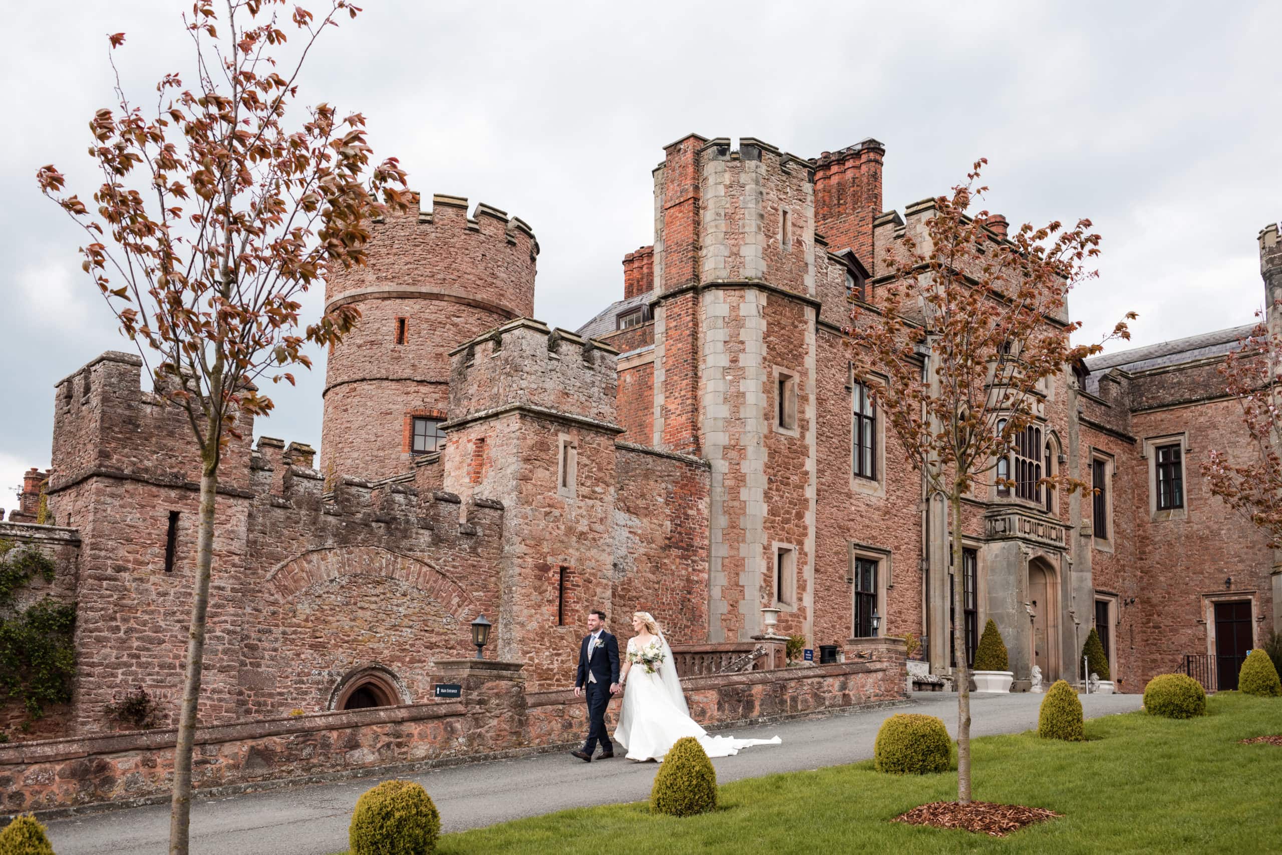 Bride and Groom walk down the driveway of Rowton Castle after their wedding