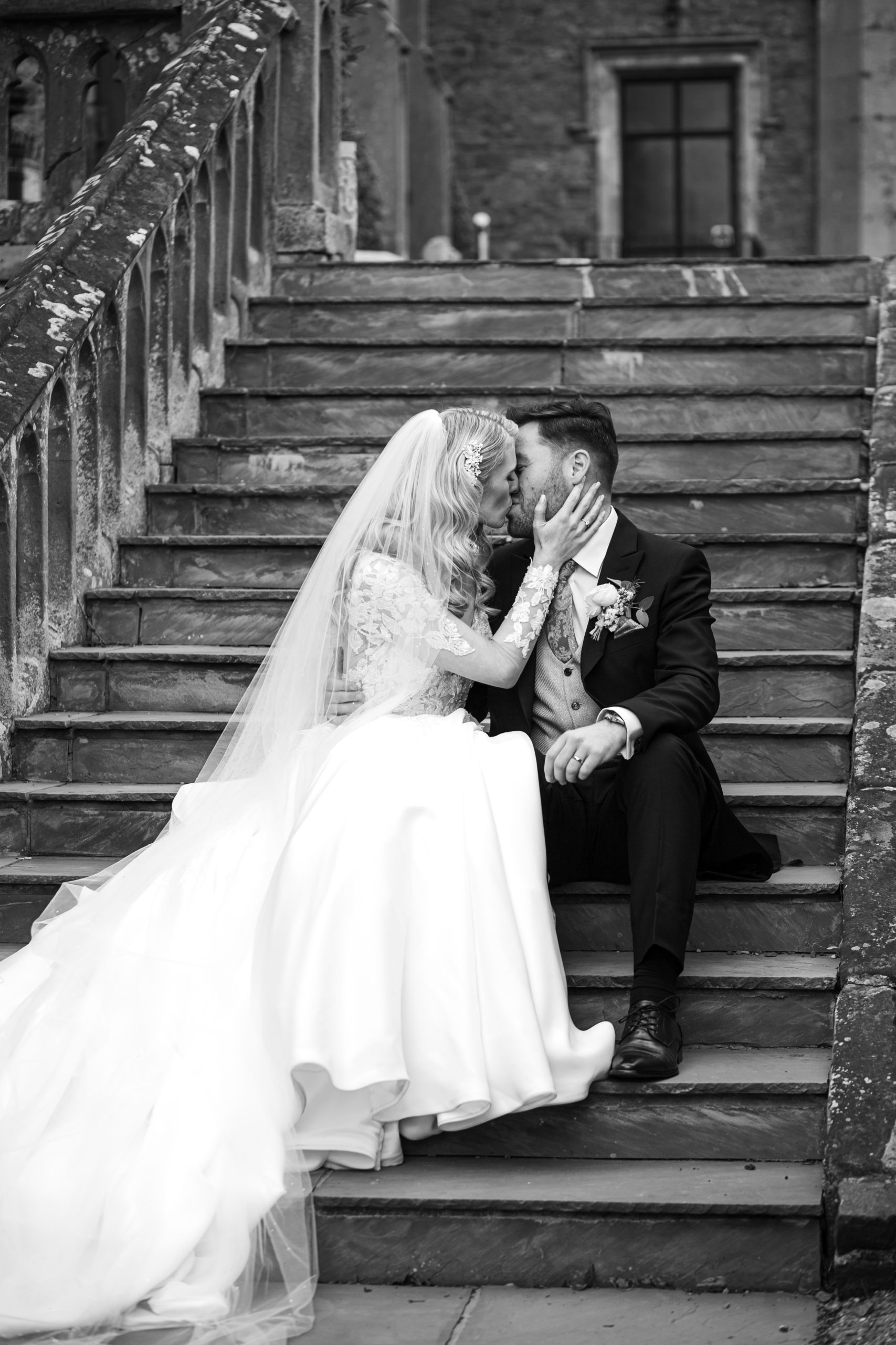 newly married couple kissing on the steps at Rowton Castle