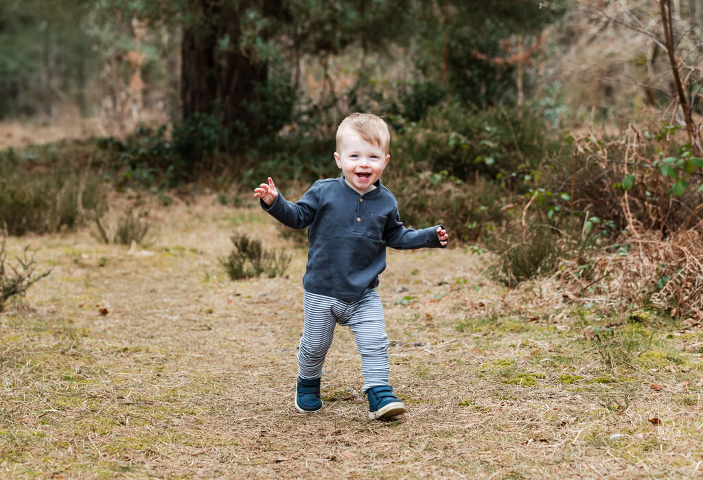 A toddler walking towards the camera outside in the nature at Sutton Park