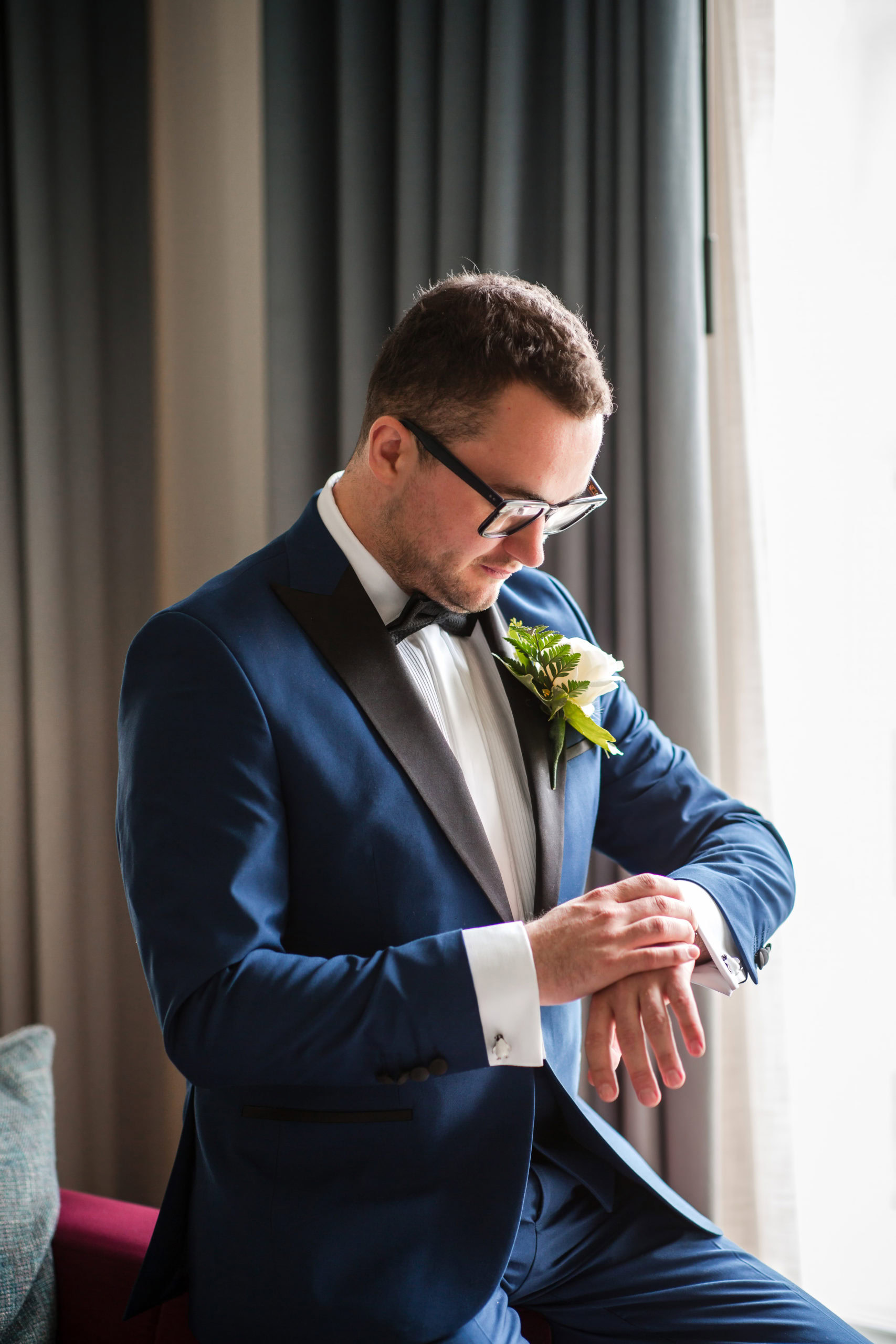 A Groom wearing a blue tuxedo getting ready for his LGBTQ+ wedding at The Grand Hotel Birmingham