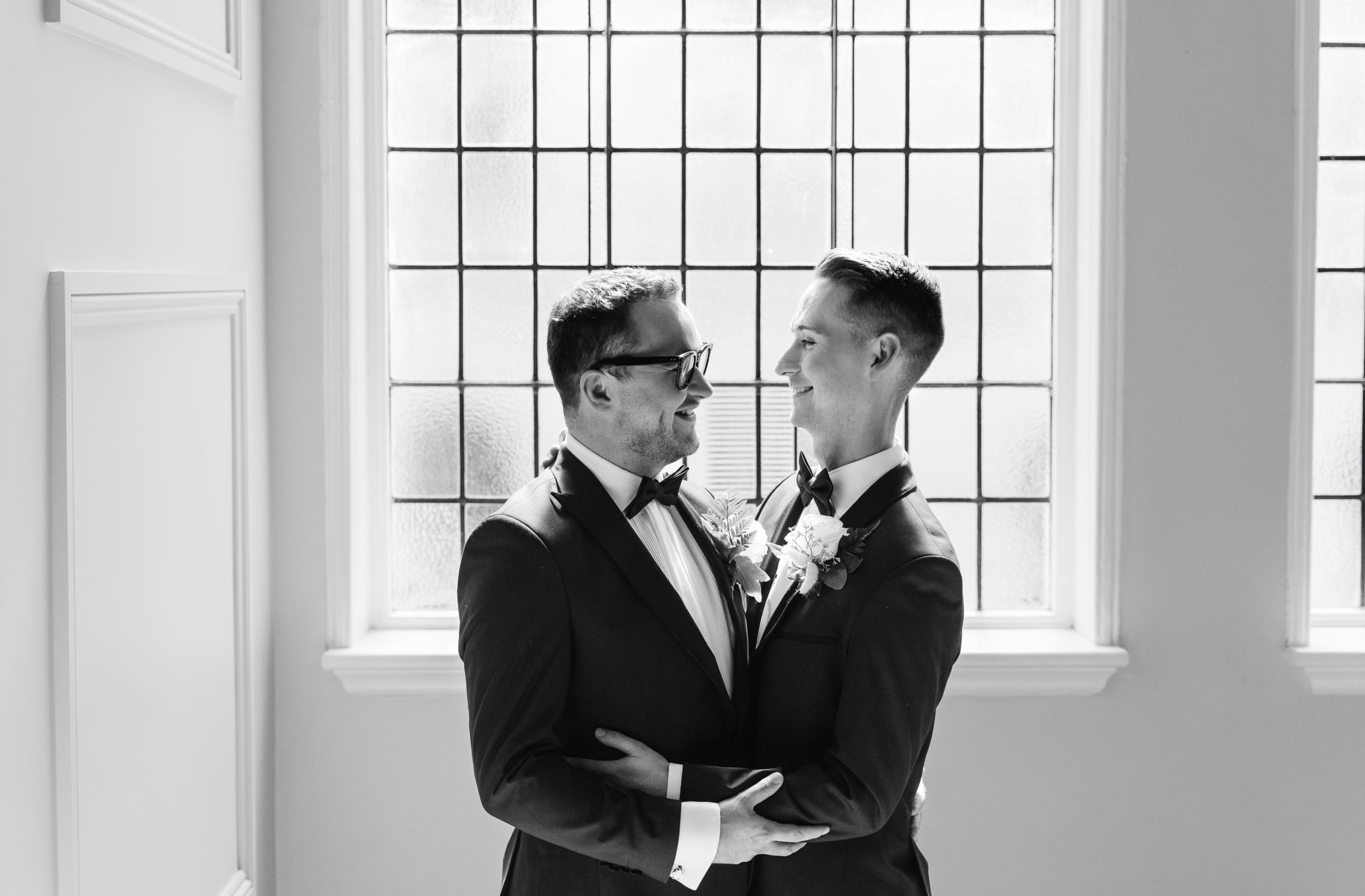 Two Grooms smile at each other for wedding photos at The Grand Hotel Birmingham